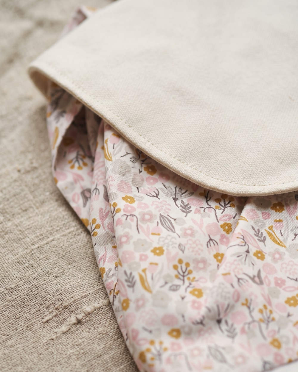 Détail du rabat en toile écrue sur l'imprimé fleuri aux petits lapins